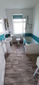 Family bathroom viewed from the hallway showing bath, shower, toilet, sink